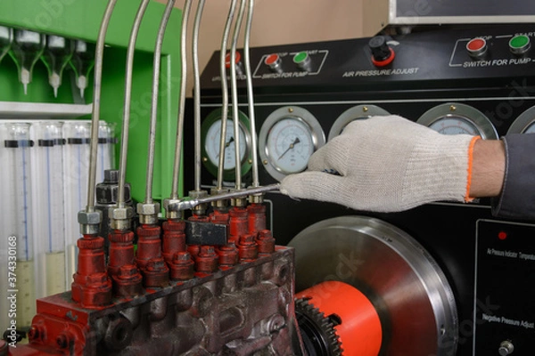 Obraz A worker chechs the operation of the fuel system at the stand. Diesel