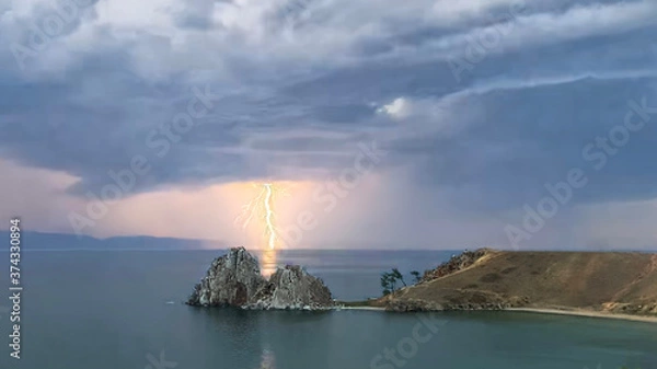 Obraz Thunderstorm on Lake Baikal. Lightning strikes through the Shamanka rock