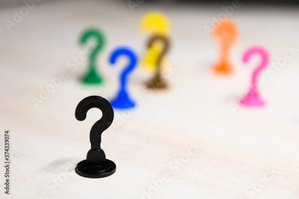 Fototapeta Problem solving and leadership illustrated with play figures in question mark shape in bright colors against white background.