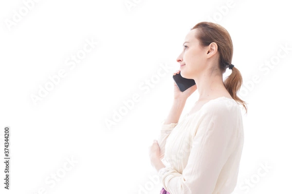 Fototapeta スマホで通話をする笑顔の若い女性