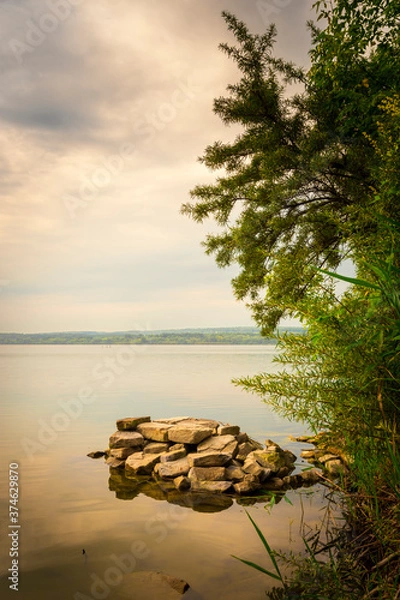 Obraz a pile of stones in the water near the shore