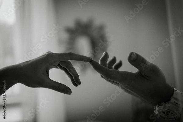 Fototapeta Hands of man and woman on the background of the window. The gentle touch of a man and a woman. Love connection help concepts. Be hand in hand. Touching each other.