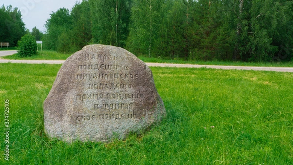Fototapeta Direction indicator. Stone pointer between two estates. Pskov region