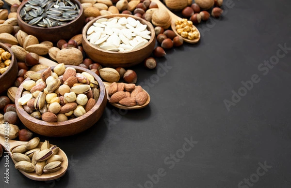 Fototapeta Mixed Nuts, dried fruits on wooden table, different kind of healthy food