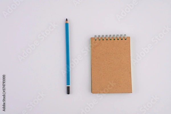 Fototapeta Pencil and brown notebook isolated on white background