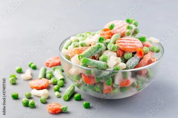 Obraz Glass bowl with frozen vegetables on table, green peas, carrot, cauliflower,  green beans, horizontal