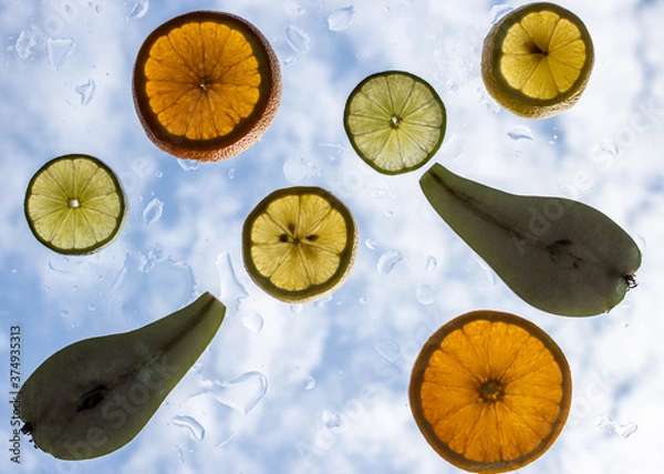 Obraz fruit slices on glass with sky background