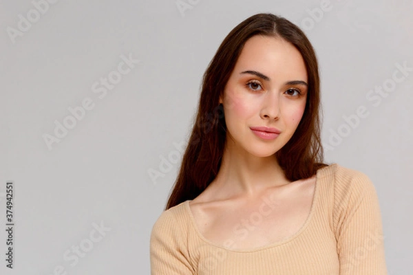 Obraz Portrait of a young beautiful cute funny girl smiling looking at the camera on a white background.