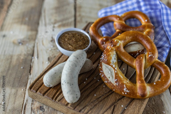 Fototapeta Oktoberfest food. Bavarian meal . White sausages, brezel and sweet mustard on wooden table