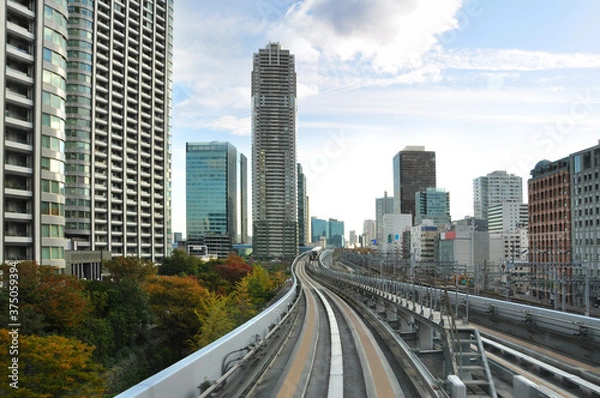 Fototapeta Jazda kolejką jednoszynową na wyspę Odaiba wśród nowoczesnej i futurystycznej architektury Tokio i jesiennych drzew