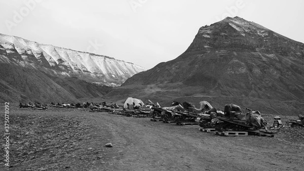 Fototapeta Snowmobiles in Longyearbyen on the island Spitsbergen waiting for the winter and the snow. Black and White picture on Svalbard.