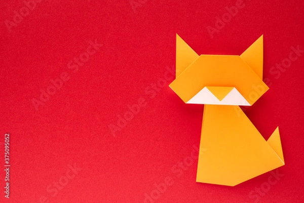 Obraz orange origami cat on red background