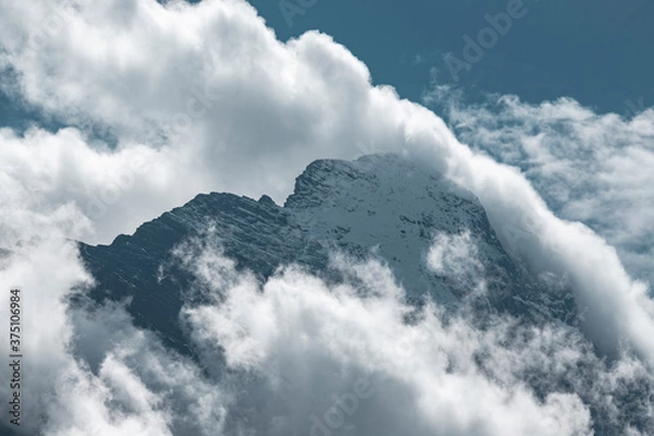 Fototapeta Floating clouds through the mountains 