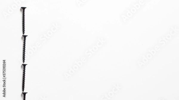 Fototapeta Self-cutters on a white background banner with space for text. Construction tools, self-tapping screws for fastening. Black screw hardware.