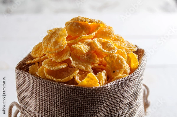 Fototapeta Cornflakes are in a linen bag. A full bag of cornflakes.