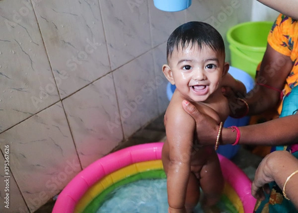 Fototapeta an infant toddler baby boy wet with foam enjoying shower bathing