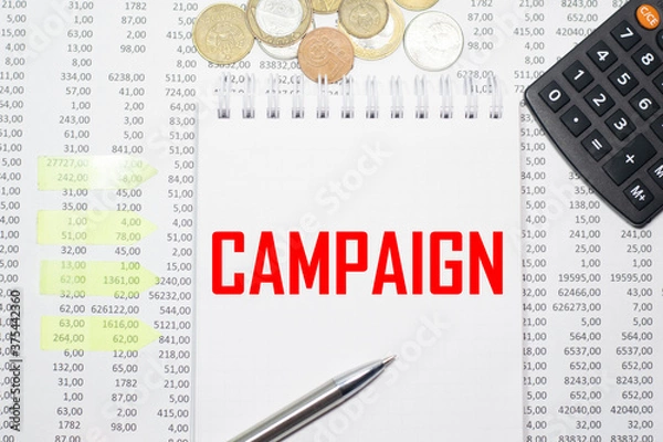 Obraz CAMPAIGN on the block on the background of financial reporting, coins, calculator, pens and yellow stickers. Business concept