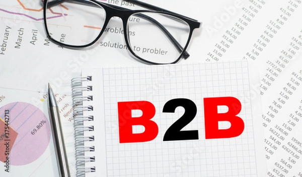 Obraz Business concept. Notebook with text b2b sheet of white paper for notes, calculator, glasses, pencil, pen, in the white background
