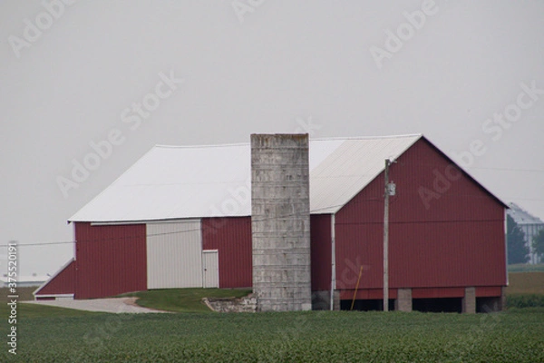 Obraz red barn in a cleared field