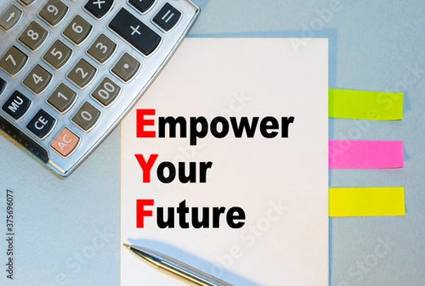Obraz Empower Your Future is written on a notepad next to multicolored stickers, a calculator and a pen on a blue background. Business concept