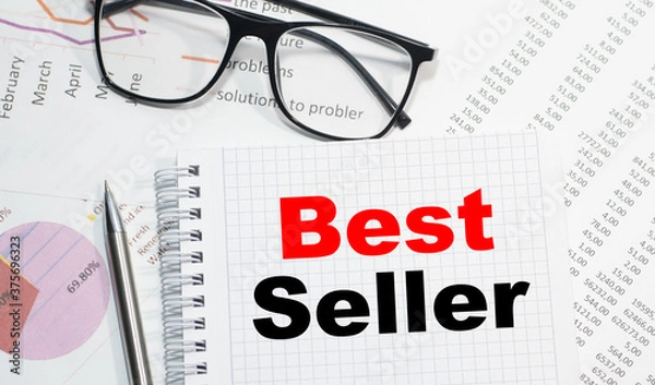 Obraz Business concept. Notebook with text Best Seller sheet of white paper for notes, calculator, glasses, pencil, pen, in the white background