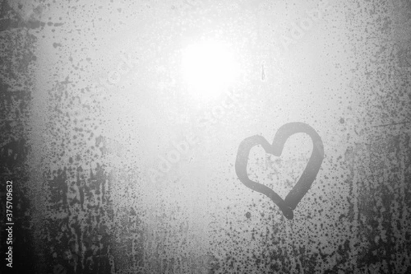 Fototapeta Blurred love heart on window, closeup on fogged drops sun shining outdoors background.