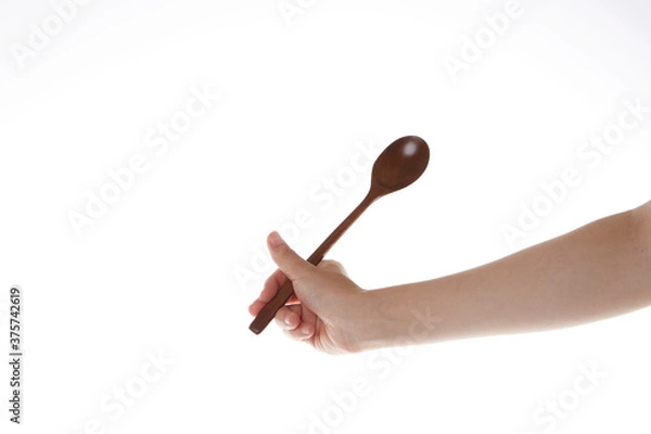 Fototapeta a hand holding a spoon upward.