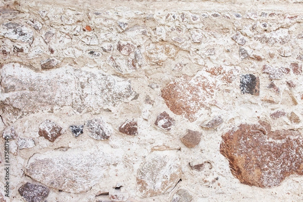 Fototapeta Stone wall texture. Mosaic rocks decorative wall background. Masonry wall of old stones. Decorative facing of the outer walls of the house.