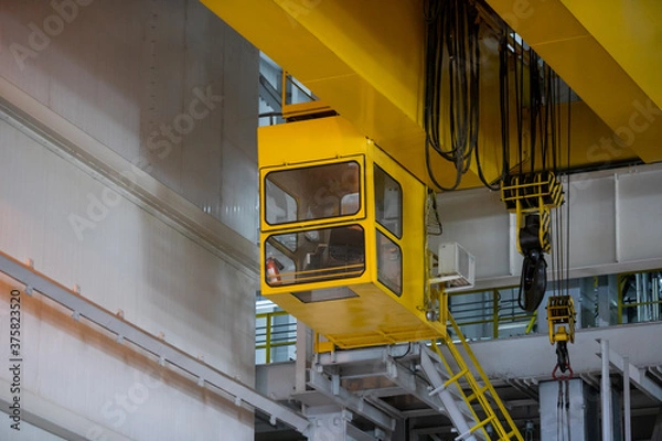 Fototapeta Part of an overhead crane in the background of an industrial workshop