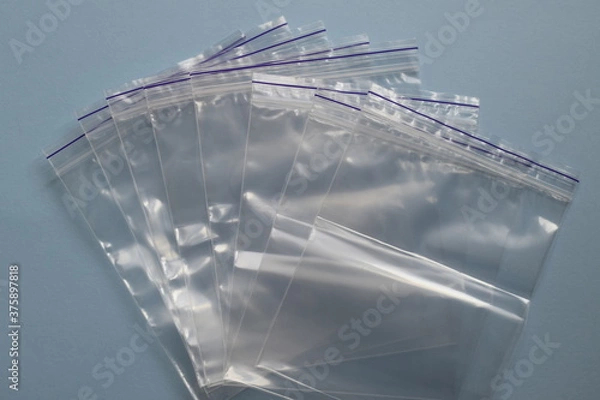 Obraz A lot of small disposable plastic bags with zip fastener on a plue background. View from above.