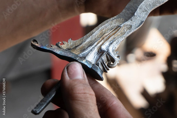 Fototapeta making traditional Balinese keris manually. The process of carving Balinese keris details are a little complicated and meticulous