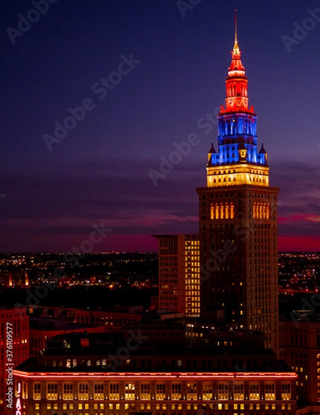 Obraz Night view of Cleveland cityscape covered in blue, purple and red shades at night / late sunset with illuminated buildings and suburbs in the background