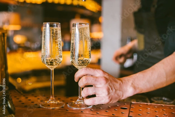 Fototapeta barman putting two glasses of prosecco on the table