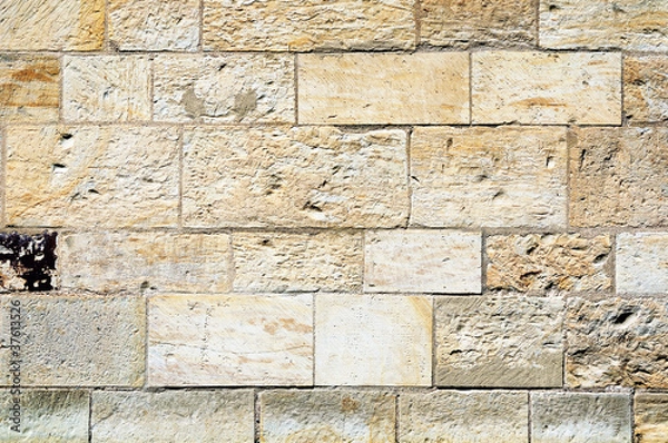 Fototapeta Fragment of a stone wall made of limestone bricks