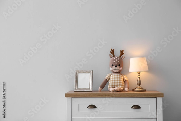 Fototapeta Modern white chest of drawers near light wall in child room, space for text. Interior design