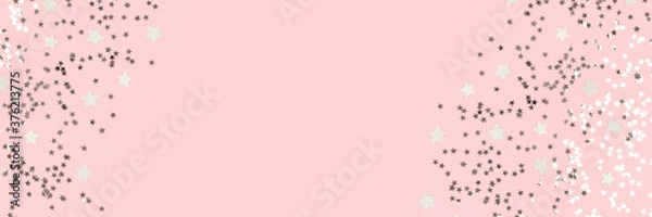 Fototapeta Ramka z konfetti w srebrne gwiazdki na pastelowym różowym tle. Baner z miejscem na tekst.
