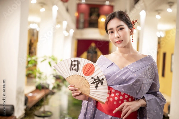 Obraz Young woman in traditional Japanese kimono and looking at camera, Japanese concept of kimono and yukata.