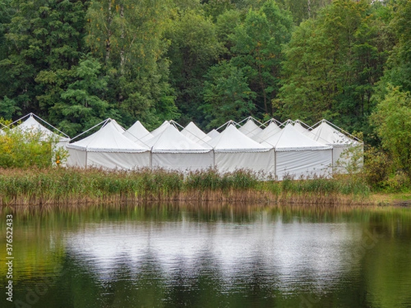 Fototapeta A view of the white tents by the water