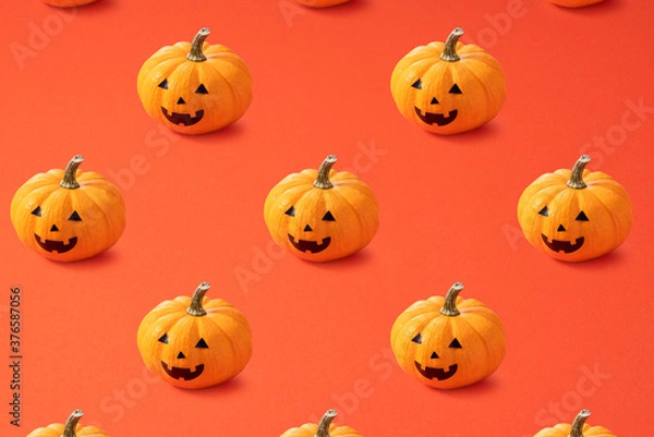 Fototapeta Jack-o-lanterns lined up regularly on an orange background