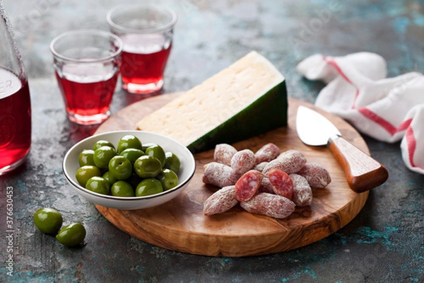 Obraz Antipasto Platter. Fuet mini sausages, green olives and cheese on wooden cutting board, selective focus