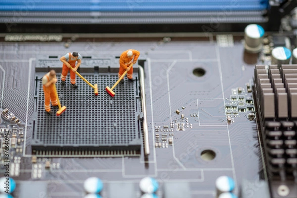 Fototapeta Miniature People: Worker cleaning professional repairman holding a cleaning brush inside old personal computer. CPU cleaning and maintenance concept, close up view..