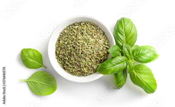 Obraz Dry marjoram in bowl and fresh basil leaves isolated on white background. Top view.