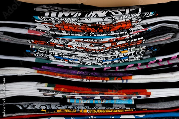 Fototapeta selective focus photo of t-shirts with bright prints, printed by silkscreen. serigraphy production. printing images on t-shirts in a design studio.
