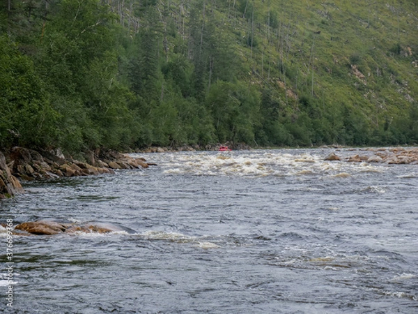 Obraz Rifts and rapids on a mountain river against the background of mountains and forests in summer swimming facility in the distance