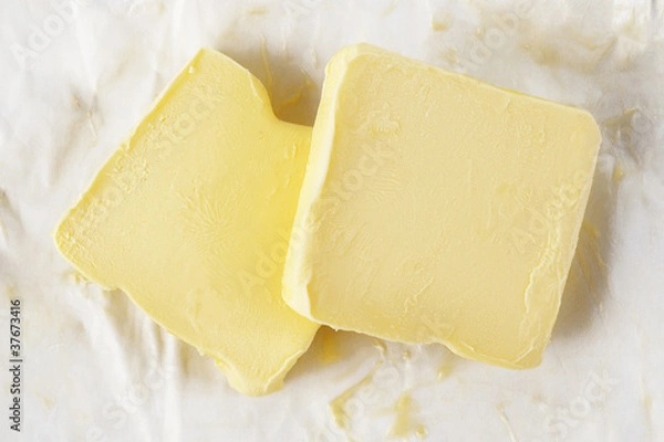 Fototapeta Piece of butter in paper on white background