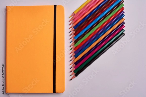 Obraz colored pencils and notepad on a white background