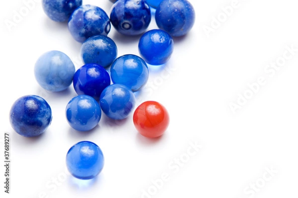 Fototapeta Red marble standing out in a crowd of blue marbles