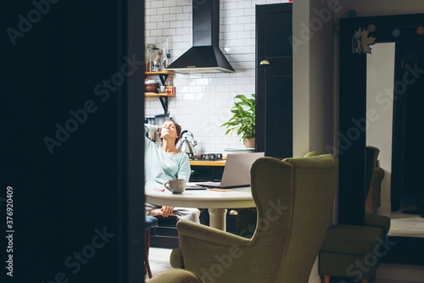 Fototapeta Young woman working at her home office on laptop