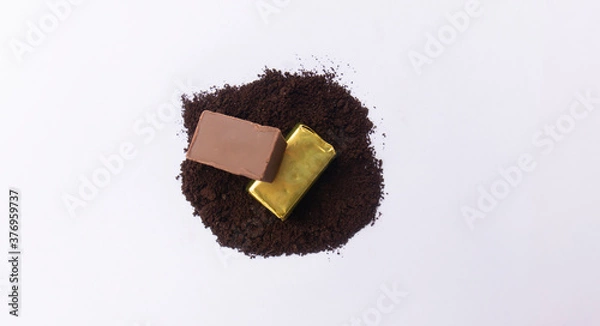 Fototapeta Close-up of a few ounces of chocolate on cocoa powder. On a white background