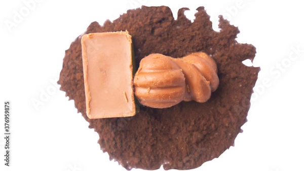Fototapeta Close-up of a few ounces of chocolate on cocoa powder. On a white background